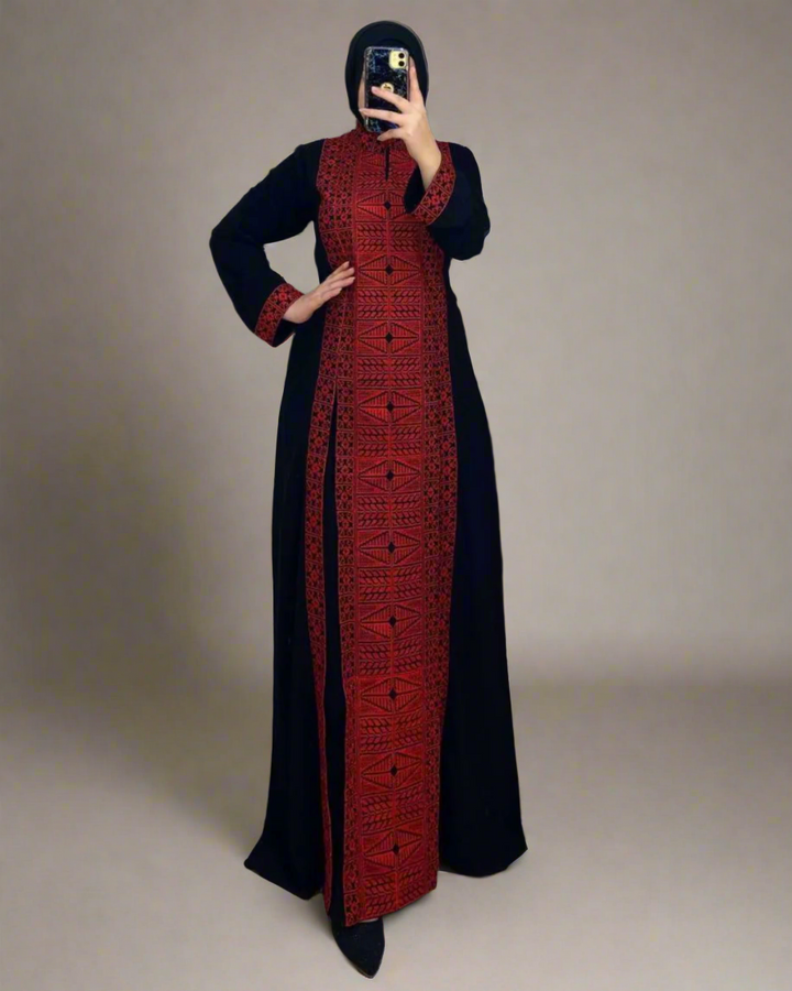 Black Palestinian abaya with gold, white, and red etamine embroidery, blending traditional Palestinian and Moroccan design, made from premium Saudi crepe fabric.

