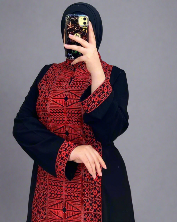 Black Palestinian abaya with gold, white, and red etamine embroidery, blending traditional Palestinian and Moroccan design, made from premium Saudi crepe fabric