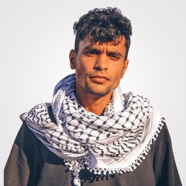 "A traditional Palestinian shawl in white and black, intricately woven or embroidered with Palestinian motifs using a combination of white and black threads. These designs often feature geometric patterns or floral motifs that symbolize cultural heritage and skilled craftsmanship. Crafted from cotton, this shawl embodies cultural pride and timeless elegance."
